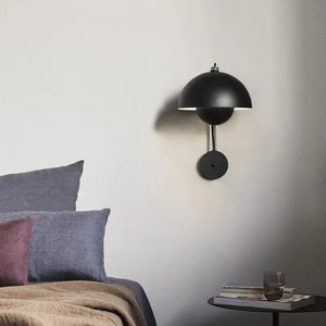 Black dome-shaped wall sconce with a circular base.