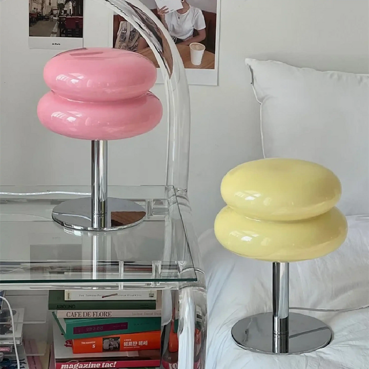 Colorful stool-shaped lamps with round, stacked cushion-like tops on metal bases.