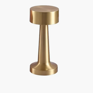 Gold-colored metal cylindrical object with a wider top and narrower base.