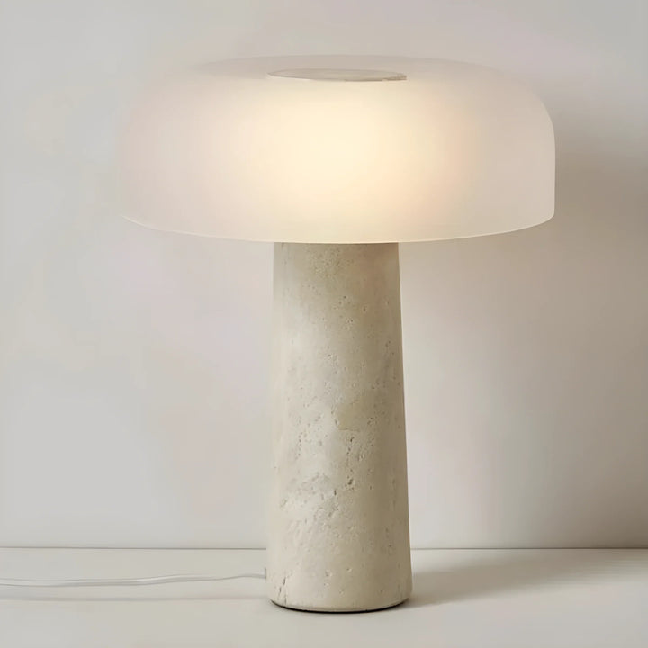 Modern table lamp with a cylindrical concrete base and a wide, glowing mushroom-shaped shade.