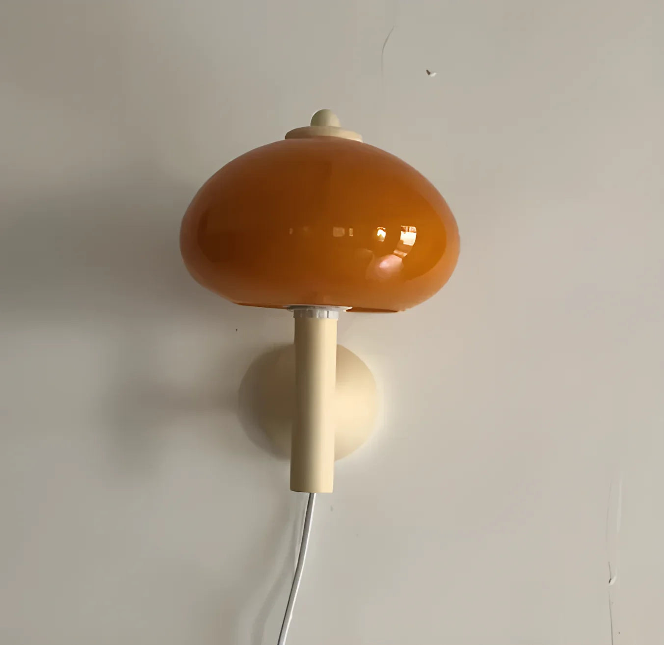 Mushroom-shaped orange lamp with a white stem and cord.