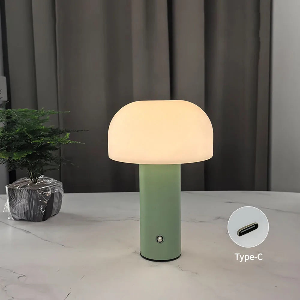 Mushroom-shaped table lamp with a green base and glowing white dome shade.