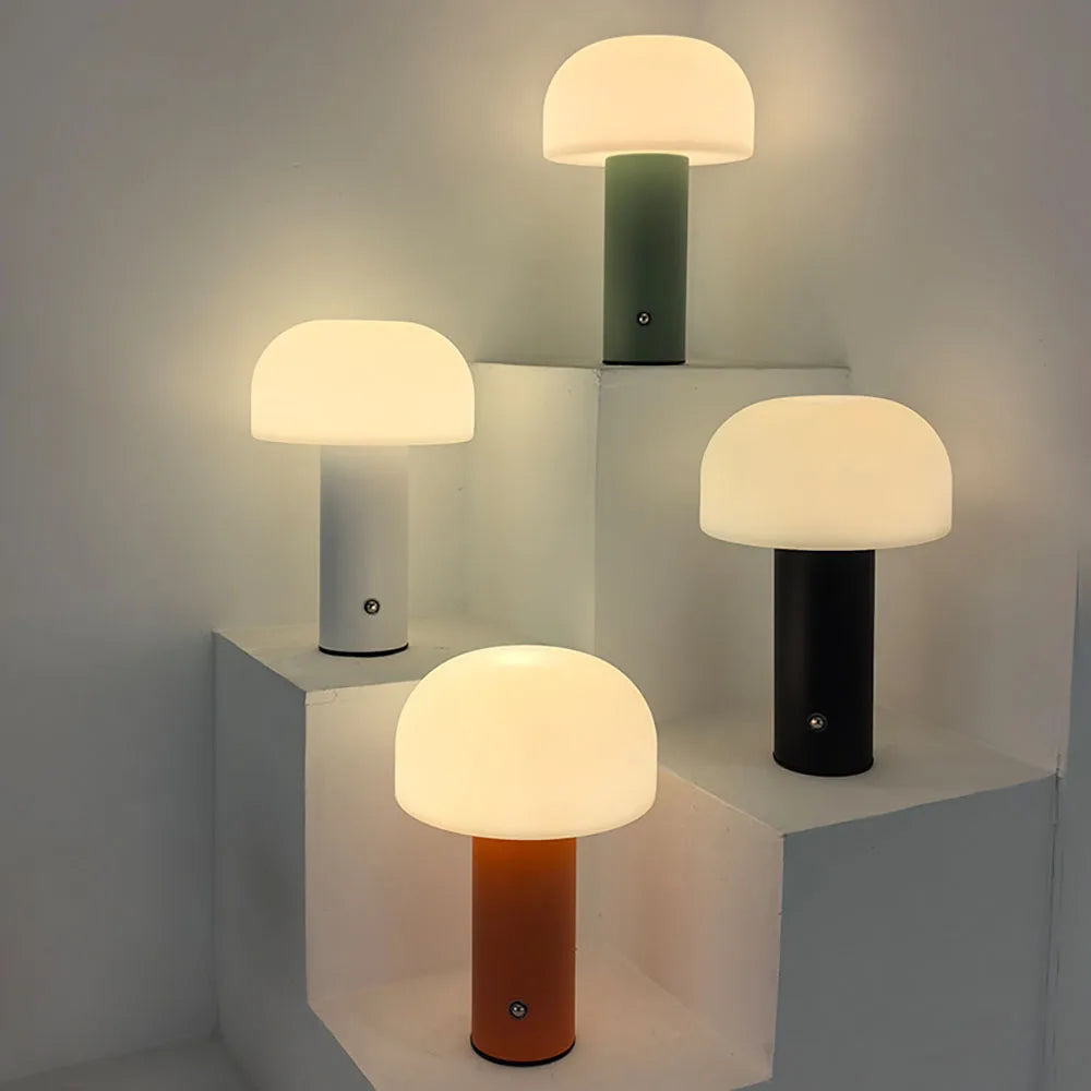 Mushroom-shaped table lamps with cylindrical bases in different colors.