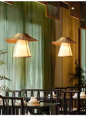 Pair of illuminated pendant lamps with wide, angular shades.