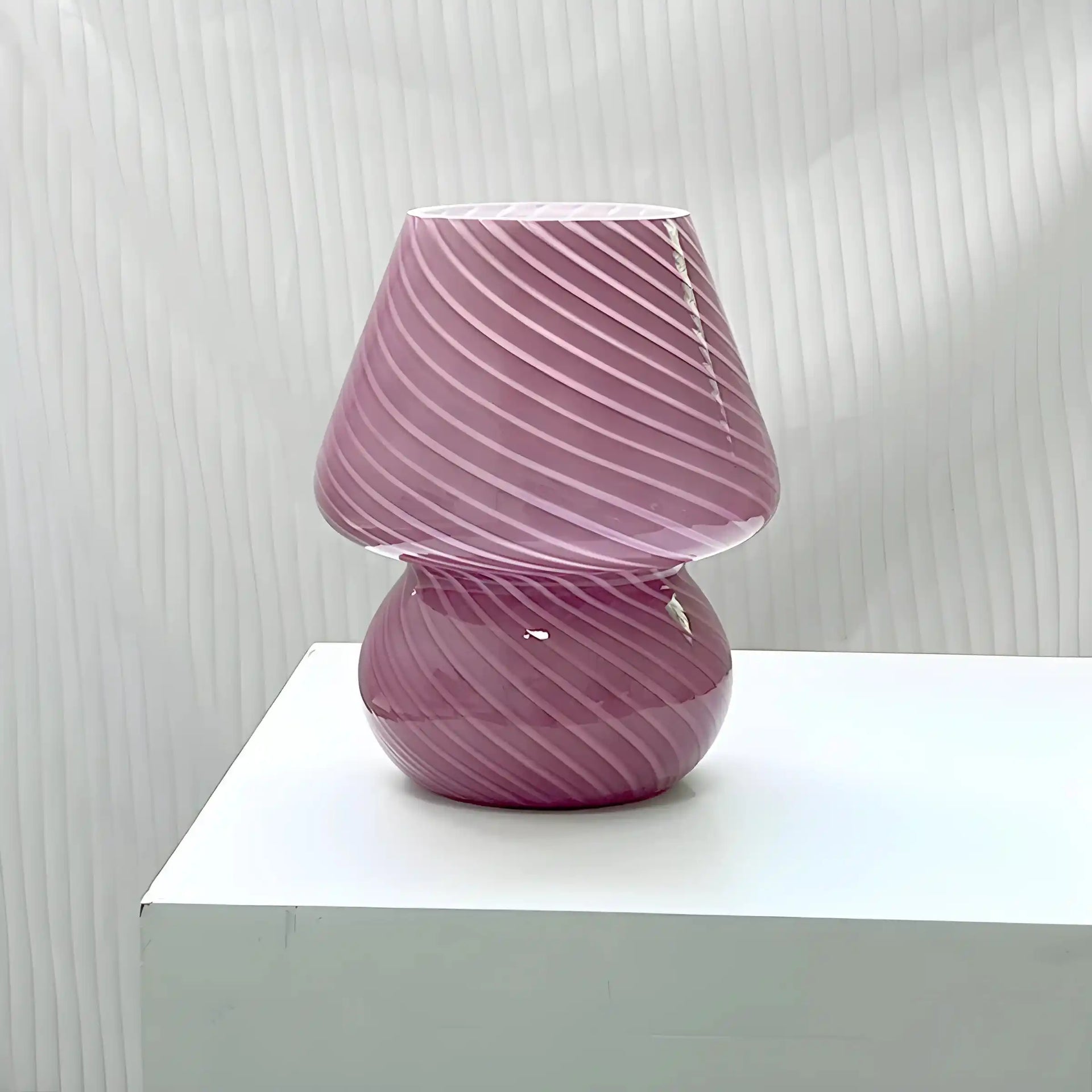 Pink glass lamp with spiral pattern.