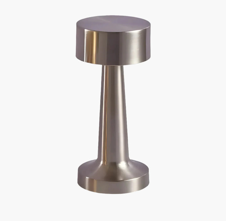 Metallic cylindrical object with a wider top and base, resembling a modern door stopper or decorative accent piece.