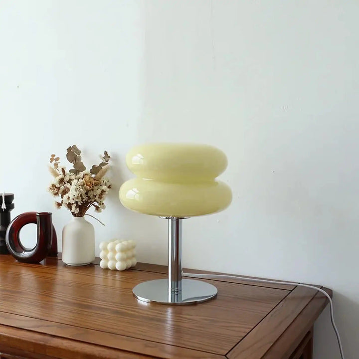 Pale yellow table lamp with a rounded, stacked shade on a metal base.