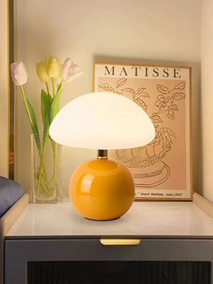 Yellow spherical base table lamp with a white dome shade.